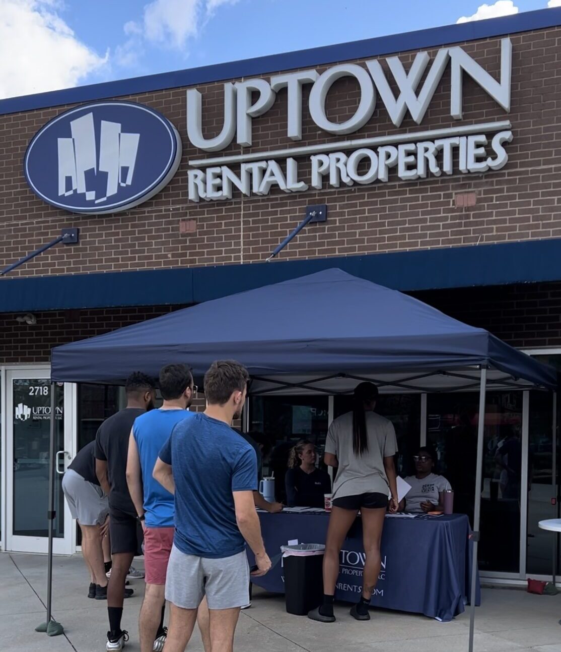 Outside of Uptown Rental Properties office, new residents pick up keys.
